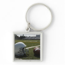 Football and football helmet on football field key chains