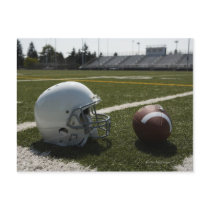 Football and football helmet on football field post cards