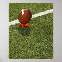 Football atop tee on football field, elevated posters