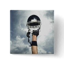 Football player holding helmet in air pinback button