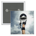 Football player holding helmet in air pinback button