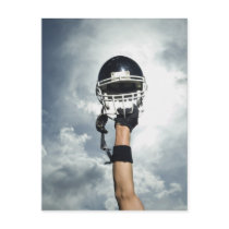 Football player holding helmet in air postcard