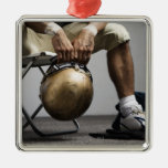 Football player sitting in locker room christmas tree ornaments