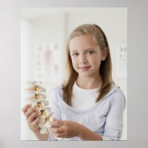 Girl holding model of spine in doctors office print