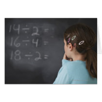 Girl looking at math equations on blackboard greeting cards