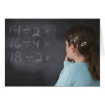 Girl looking at math equations on blackboard greeting cards