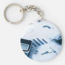 hand and pen writing amongst financial figures key chains