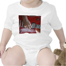 Hand playing red electric guitar near pickup bodysuit