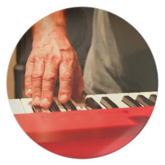 hand playing red keyboard male musician dinner plate