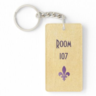 The key to Room 107 or any other room at a hotel or apartment . With fleur de lys on sandy background.