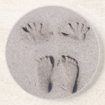 La mano y los pies imprime en arena de la playa de posavaso para bebida