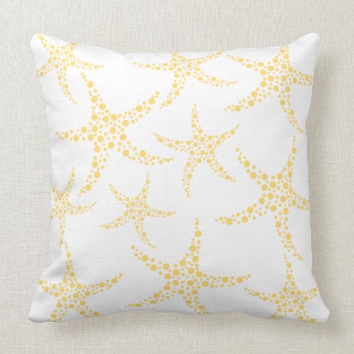 Las estrellas de mar modelan en amarillo y blanco almohadas