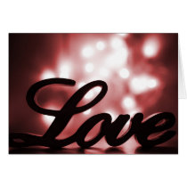 Love sign with red sparkle lights behind cards