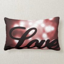 Love sign with red sparkle lights behind pillows