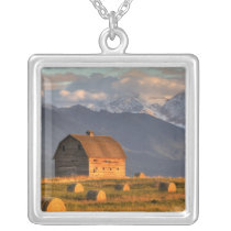 Old barn framed by hay bales and dramatic personalized necklace