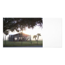 Old ranch building under trees with man statue picture card