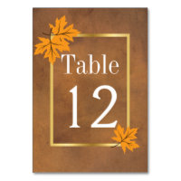 Orange maple leaves on brown wedding table number table cards