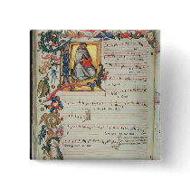 Page of musical notation with a historiated buttons
