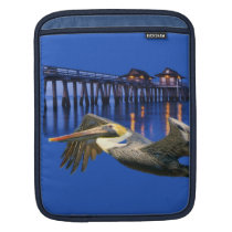 Pelican flying with tropical pier in background Ri Ipad Sleeves