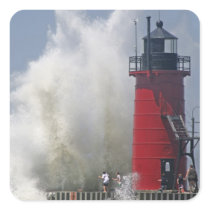 People on jetty watch large breaking waves in