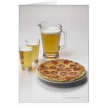 Pitcher and two pints of beer beside pepperoni greeting card