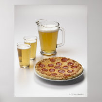 Pitcher and two pints of beer beside pepperoni poster