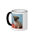 Pug puppy sitting on bed coffee mug