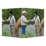 Ranchers shaking hands across the fencing in binders
