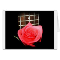 Red pink rose against five string bass fret board cards