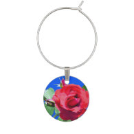 red rose flower and green leaves in blue wine glass charm