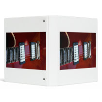 Red semi hollow guitar picture of strings, pickups 3 ring binder