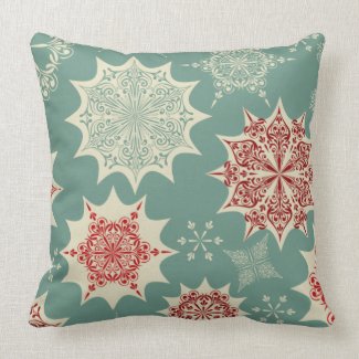 Red snowflakes on a green background pillow