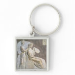 Relief depicting a woman at her toile keychain