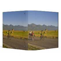 Road bicyclists ride down a back country road vinyl binders