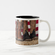 Row of cowboy boots on haystack coffee mug