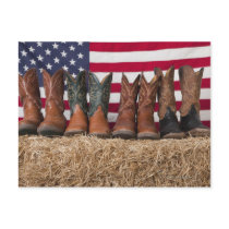 Row of cowboy boots on haystack postcard