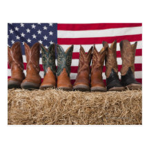 Row of cowboy boots on haystack postcard
