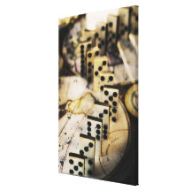 Row of dominoes on old world map stretched canvas print