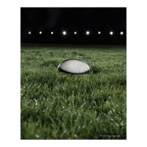 Rugby ball sitting on the grass pitch of a print