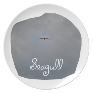 Seagull flying in a grey sky with text Seagull plate