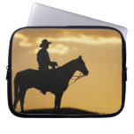 Silhouette of cowboy on horseback at sunset or laptop sleeves
