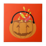 Smiling Halloween pumpkin filling with candy Ceramic Tile