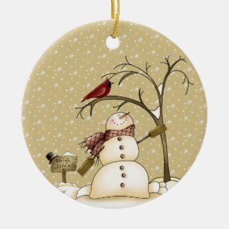 "From Our House To Yours" - cute snowman with red bird in a tree on a beige background with falling snow on a hanging ornament for the Christmas tree