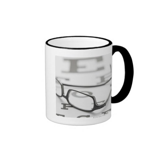 Studio shot of eyeglasses on eye chart coffee mug