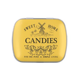 A Jelly Belly candy tin with a vintage windmill in a field with butterflies and birds with the text 'sweet home candies for the pure and simple living'. The background has a gold metal finish