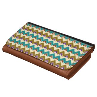 A purse with a native tribal pattern of feathered chevrons and arrows in teal, brown, red, blue and beige