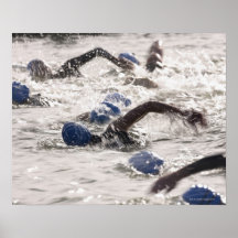 Triathletes competing in swim leg of triathlon. posters