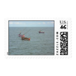 Tropical fishing boats on the sea stamp