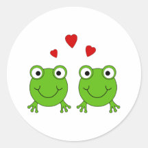 Two green frogs with red hearts. round sticker