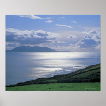 view of a grassy slope by the sea posters